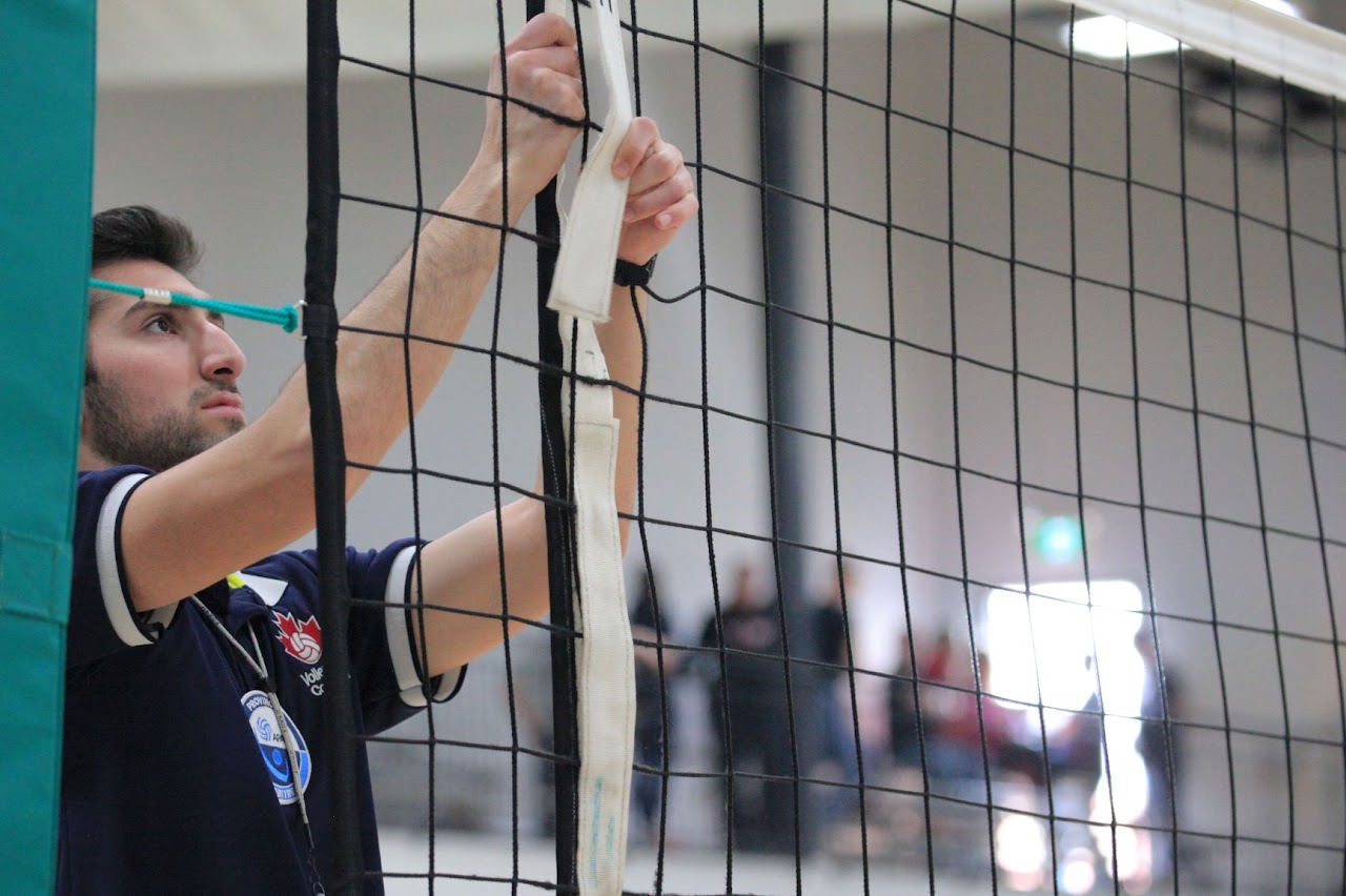 Officiel de volleyball ajustant le filet dans un gymnase